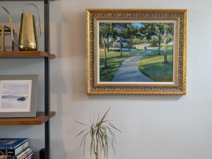 Framed painting on the wall near a bookshelf